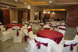 a room full of tables and chairs with red and white bows at Hotel Nilax in Jaipur