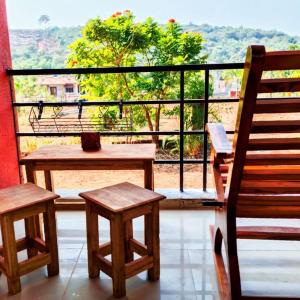 a balcony with a bench and a table and chairs at Dapolihideaway in Dapoli