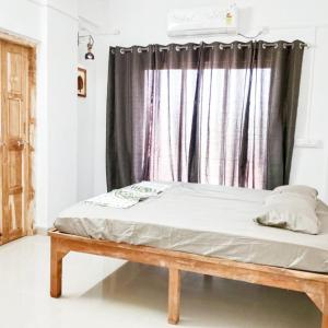 a bed in a room with a window at Dapolihideaway in Dapoli