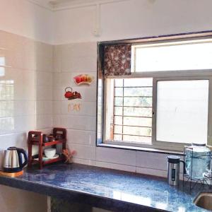 a kitchen with a sink and a window at Dapolihideaway in Dapoli