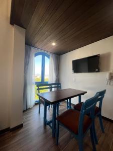 a dining room with a table and chairs and a window at Nhã Hotel A in Thôn Mỹ Phước