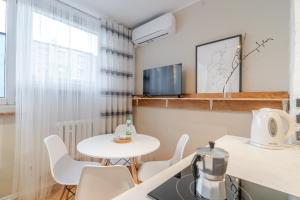a small dining room with a white table and chairs at Sosnowiec Downtown Studio by BookingHost in Sosnowiec