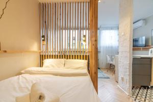 a bedroom with a bed with a wooden headboard at Sosnowiec Downtown Studio by BookingHost in Sosnowiec