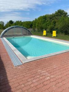 a swimming pool with two chairs on a roof at SOL Panzió in Bük