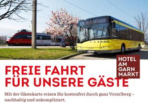 a yellow bus is parked in a parking lot at Hotel am Garnmarkt in Götzis