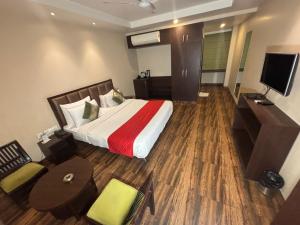 a hotel room with a bed and a television at Hotel Nilax in Jaipur