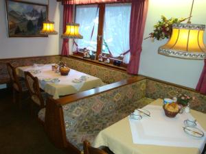 a dining room with two tables and two windows at Hotel Garni Val-Sinestra in Ischgl