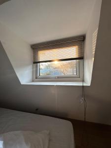 a window in a room with a bed and a window blind at The Alchemist Rishikesh in Birbhaddar