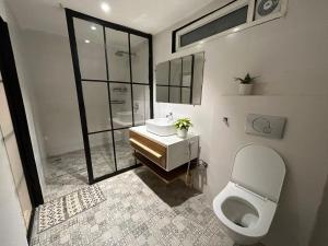 a bathroom with a white toilet and a sink at The Alchemist Rishikesh in Birbhaddar +27 photos