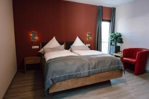 a bedroom with a large bed and a red chair at Gasthaus SEPP in Dernau