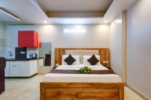 a bedroom with a bed and a kitchen at The Palm Suites - Medicity in Gurgaon