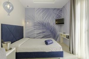 a bedroom with a bed with a blue patterned wall at Le Gemelle Boutique Hotel in Torre Suda +63 photos
