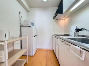 a kitchen with a white refrigerator and a sink at ura アオトハル2 in Okayama