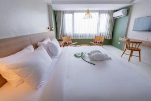 a large white bed in a room with chairs at HOTEL NUU CHIANG MAI in Chiang Mai +44 photos