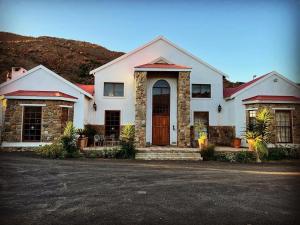 a large white house with a front porch at Waterval Karoo Guest Farm in Laingsburg