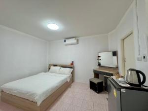 a bedroom with a bed and a television in it at Baan Kalaya Homestay in Nonthaburi
