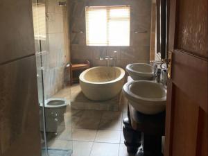 a bathroom with two sinks and a tub and two toilets at Waterval Karoo Guest Farm in Laingsburg