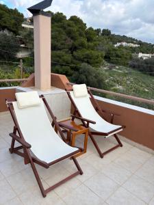 two chairs on a balcony with a view at Aegean Window - Sea View Studio in Salamina +27 photos