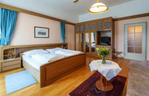 ein Schlafzimmer mit einem Bett und einer Blumenvase auf einem Tisch in der Unterkunft Altstadthotel Eck in Lienz