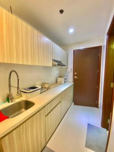 a kitchen with wooden cabinets and a sink at 2B-15 Condo Staycation at Megatower 1 in Baguio