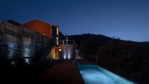 a building with a swimming pool at night at Quinta do Vale da Ermida, Private - Heated - Pool in Ermida