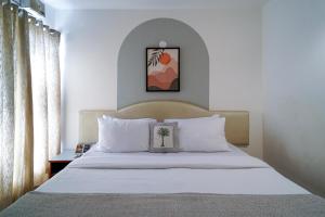 a bedroom with a large bed with white pillows at Olive Zip Calangute Mira by Embassy Group in Calangute +45 photos