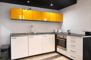 a kitchen with white cabinets and a sink at Valletta Maisonette Malta in Valletta