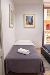 a bedroom with a bed with a towel on it at Valletta Maisonette Malta in Valletta