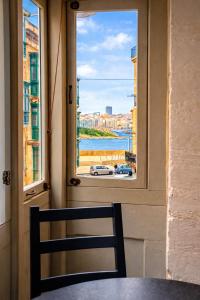 a chair sitting at a table looking out a window at Valletta Maisonette Malta in Valletta
