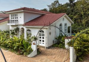 a white house with a red roof at LohonoStays Calisto Villa E in Camorlim