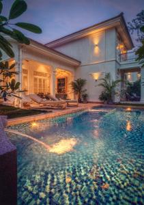 a large swimming pool in front of a house at LohonoStays Calisto Villa E in Camorlim