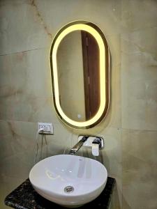 a bathroom with a white sink and a mirror at R N Hotel & Lawn in Katra