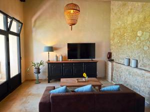 ein Wohnzimmer mit Sofa und Flachbildfernseher in der Unterkunft Que Pour 2 in Mauroux