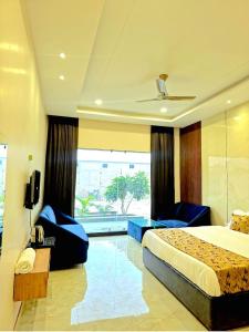 a hotel room with a bed and a large window at R N Hotel & Lawn in Katra
