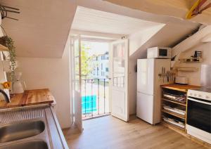 a kitchen with a white refrigerator and a large window at SURF HOSTEL BIARRITZ in Biarritz