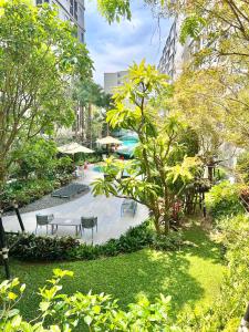 a park with benches and tables and trees at Dcondo Reef Serenity Condo 2 in Phuket