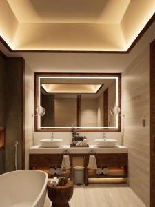 a bathroom with two sinks and a large mirror at Avala Nusa Dua Bali in Bali Nusa Dua