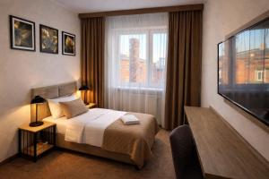 a hotel room with a bed and a television at Załęże in Katowice