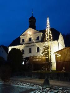 a christmas tree in front of a white building at Landhotel Thürmchen in Schirgiswalde