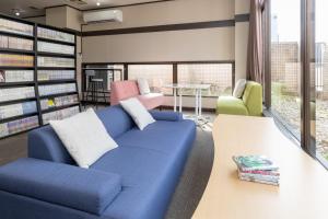 a living room with a blue couch in a library at Mito Hotel Season in Mito