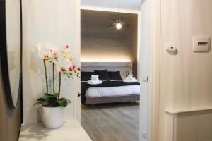 ein Schlafzimmer mit einem Bett und einer Topfpflanze in der Unterkunft L'Airone Resort - Soggiorno rilassante in Irpinia in Venticano
