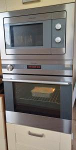 a microwave oven with a pizza inside of it at Crystal Baltic Studio Gdańsk self check in - 24h in Gdańsk +10 photos