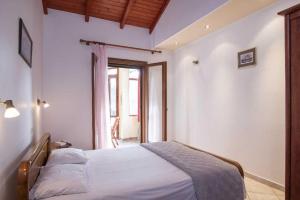 a bedroom with a bed and a large window at Krista House in Agios Gordios