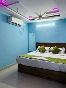 a bedroom with a bed with a blue wall at Hotel ANR Grand in Visakhapatnam