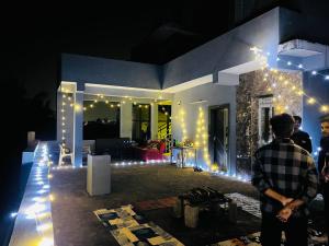 a group of people standing in front of a house with lights at Hotel ANR Grand in Visakhapatnam