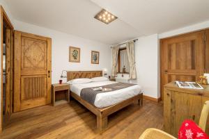 a bedroom with a bed and a wooden door at Maison Carrel Elegant 6 in Breuil-Cervinia