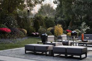 a group of benches and tables in a garden at Shanghai Qiuzhu Hotel - Near Shanghai Disney Resort & Wildlife Park - Free Buffet Breakfast - Pick-up Service for Disneyland, PVG Airport, Wildlife Park & Xinchang Metro Station in Shanghai