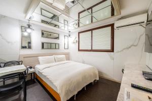 a small bedroom with a bed and a window at Hotel Campanella in Seoul
