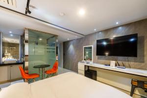 a bedroom with a bed and a desk with a tv at Hotel Campanella in Seoul