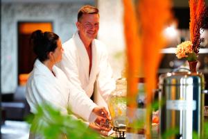 a man and a woman standing at a table at Wellnesshotel Golfpanorama in Lipperswil +60 photos